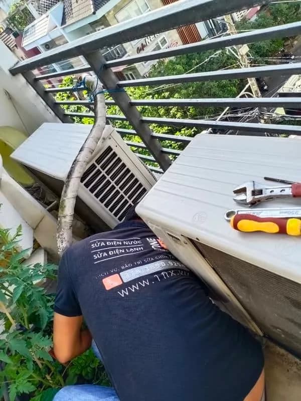 Thợ 1Fix đang sửa chữa cục nóng máy lạnh tại nhà khách hàng