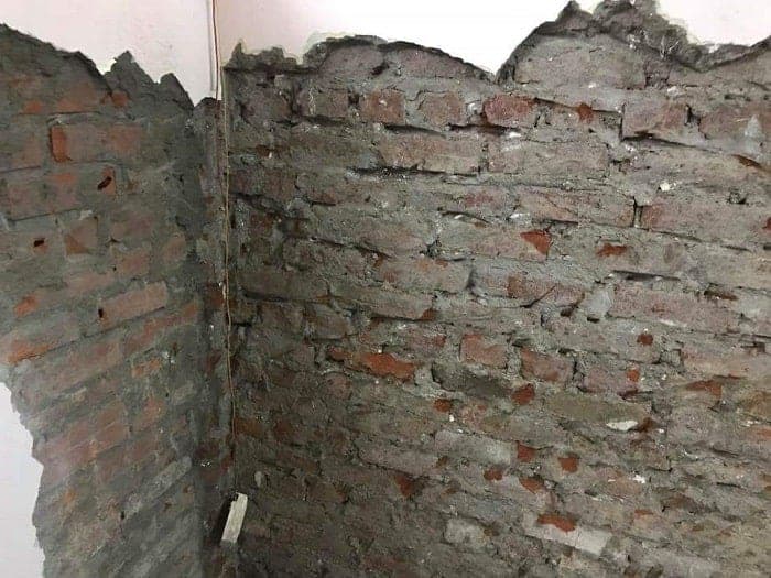 Thợ chuyên nghiệp đang thi công lớp chống thấm cho bề mặt tường gạch.