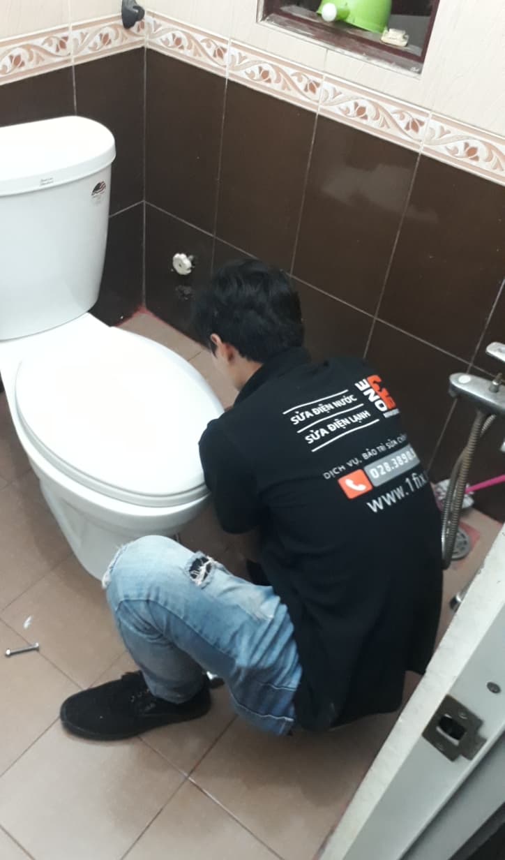 Thợ đang kiểm tra bên trong két nước để tìm nguyên nhân rò rỉ.