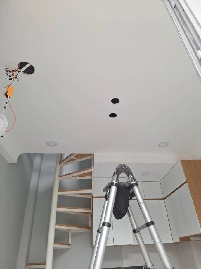 Trước khi lắp đặt: trần thạch cao còn lỗ chờ và dây điện, thang chữ A dựng sẵn tại Quận 7 — thợ Trần Quốc Đông