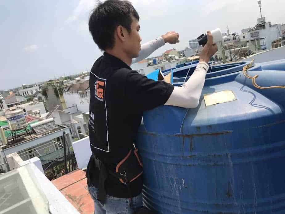 Thợ 1Fix đang lắp đặt phao điện chống tràn cho bồn nước trên sân thượng.