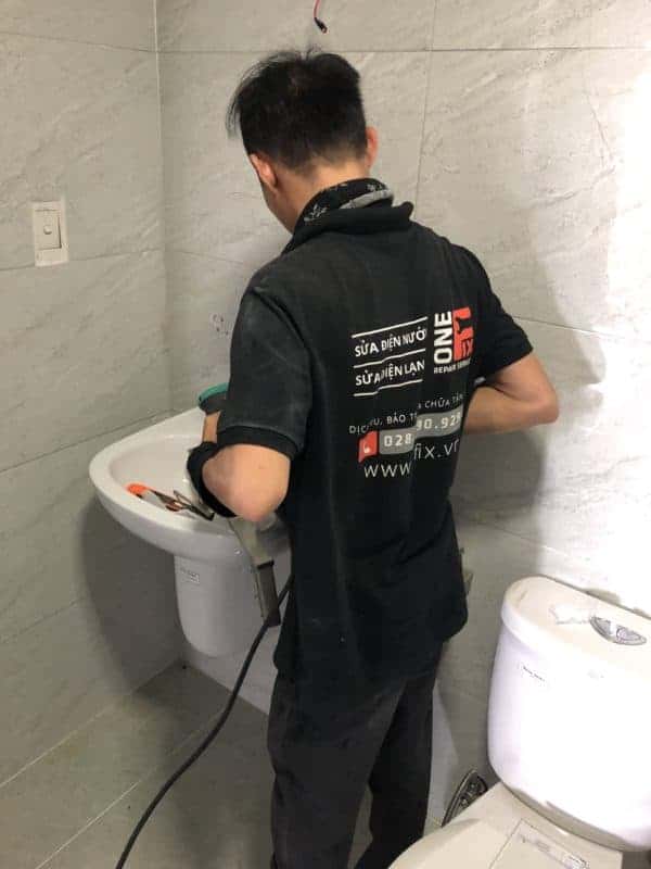 Thợ 1Fix đang sửa vòi nước lavabo bị rỉ nước tại nhà khách ở TPHCM.
