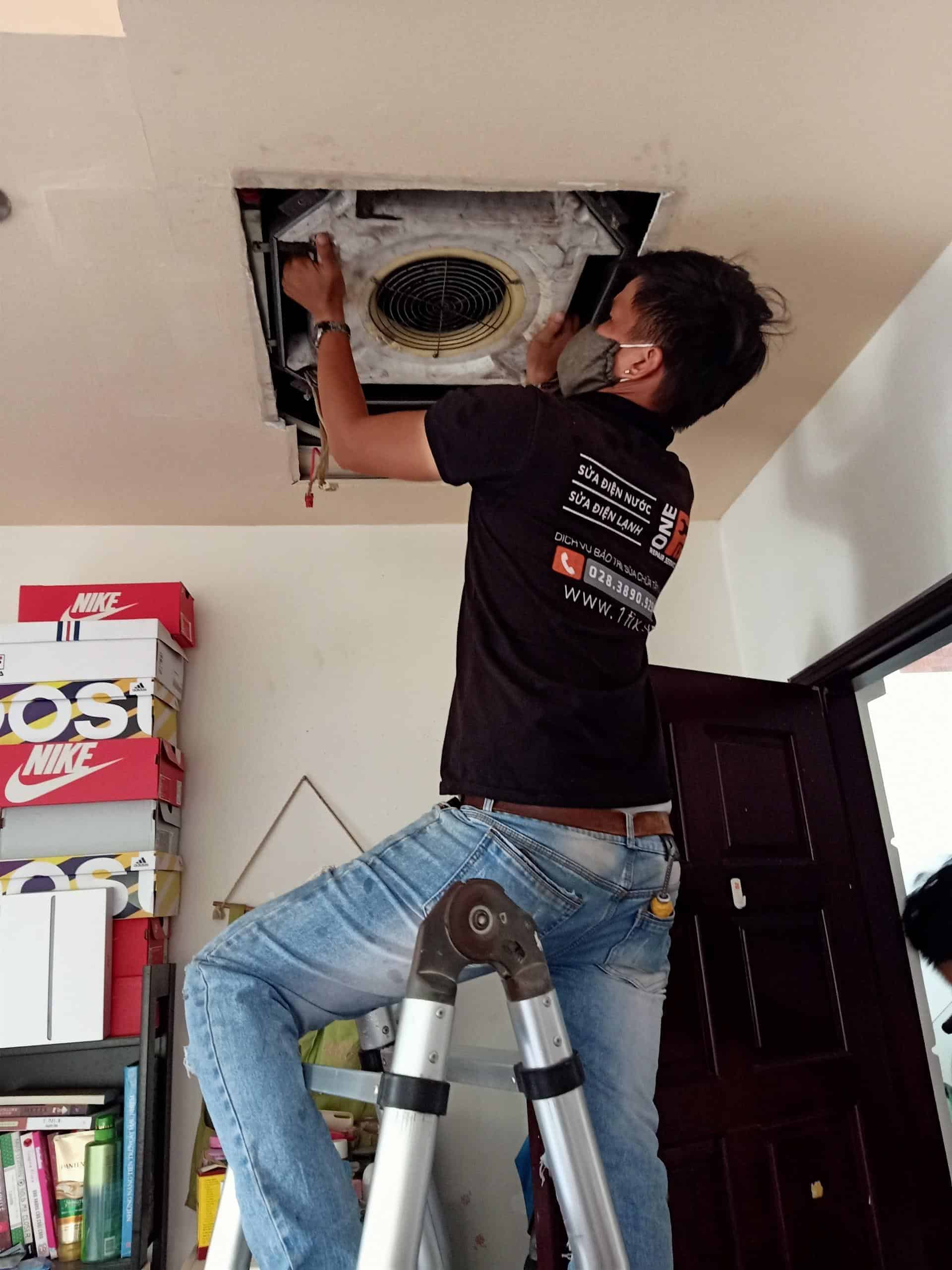 Kỹ thuật viên đang dùng bạt che chắn cẩn thận khi vệ sinh máy lạnh