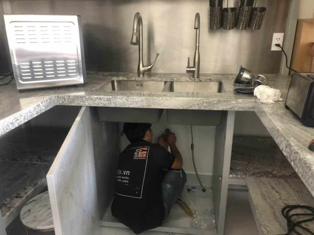 Thợ 1Fix đang lắp đặt vòi nước mới cho bồn rửa chén.