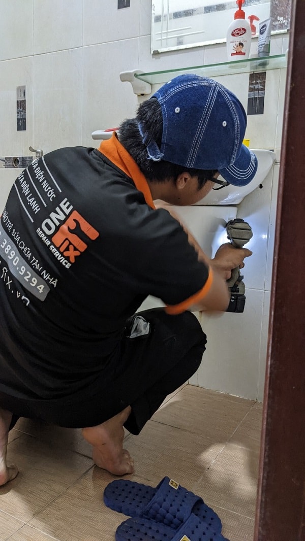 Thợ 1Fix đang dùng máy lò xo chuyên dụng để thông tắc lavabo