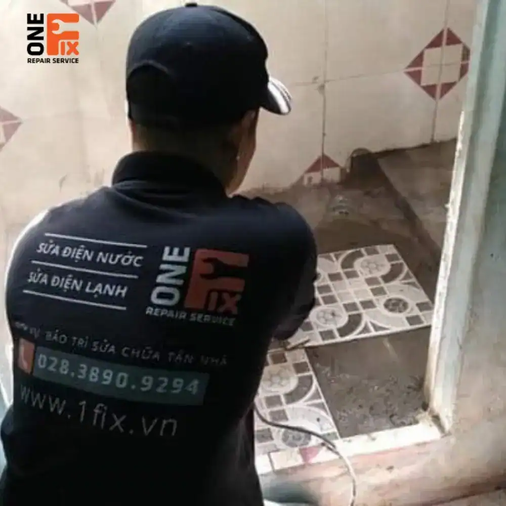 Hình ảnh thực tế sàn nhà vệ sinh bị thấm nước loang lổ, ron gạch ố vàng.