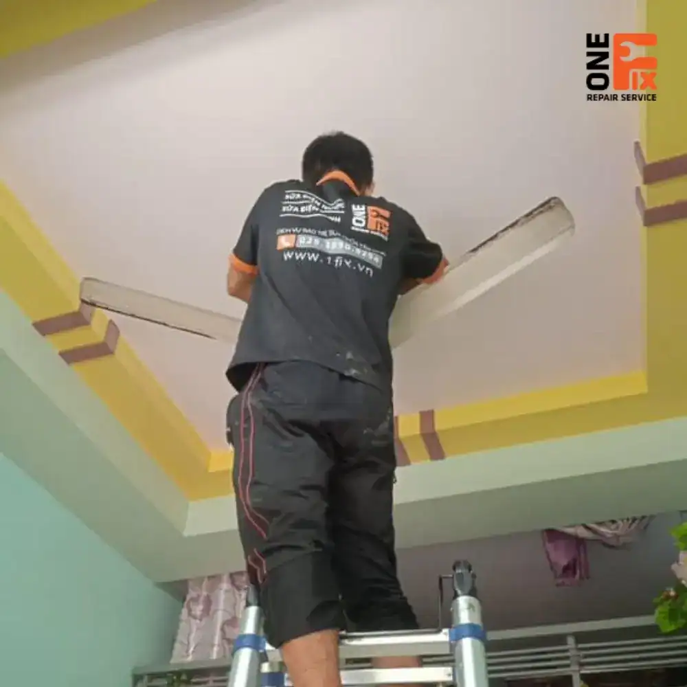 Thợ 1Fix đang kiểm tra và gia cố khung sắt trước khi lắp quạt trần trên trần thạch cao.