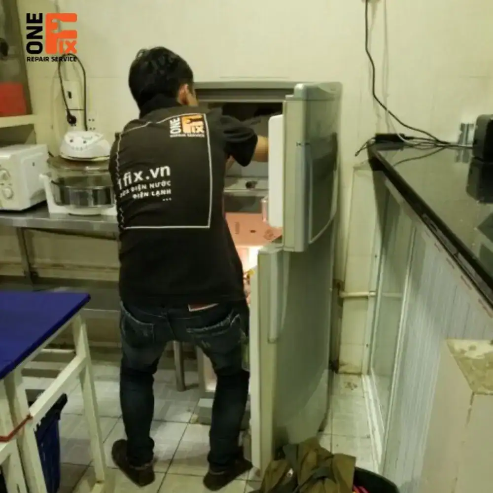 Thợ 1FIX đang kiểm tra tình trạng tủ lạnh không lạnh tại nhà khách ở TPHCM