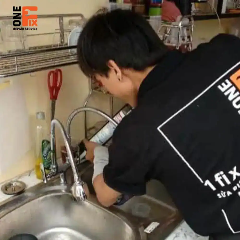 Thợ 1Fix đang sửa vòi nước rò rỉ ngay tại chân vòi cho khách hàng.