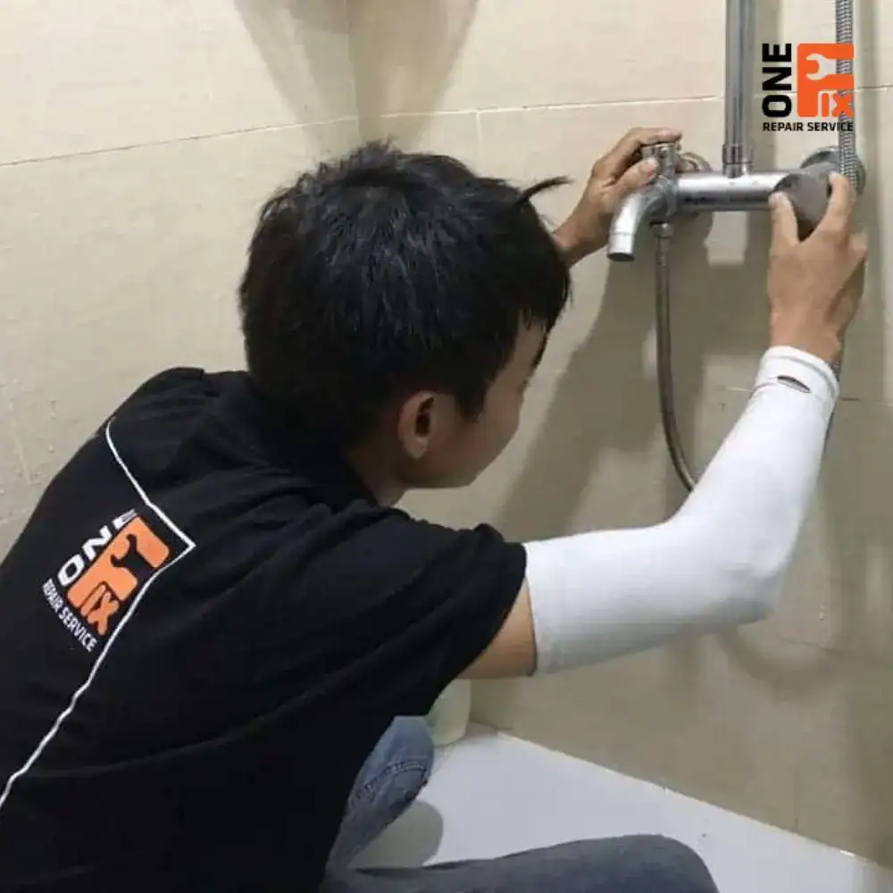 Thợ 1Fix đang tháo và kiểm tra vệ sinh lưới lọc đầu vòi nước bị tắc nghẽn gây chảy yếu